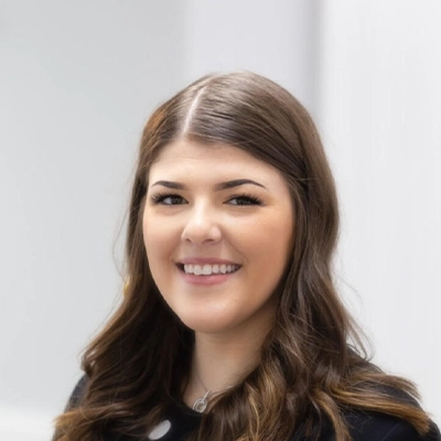 Office Manager Alina Smiling In Front Of Blurred Background