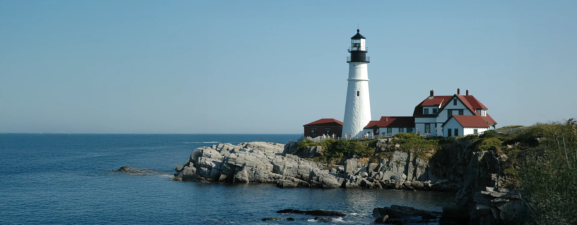 Lighthouse On A Rocky Point In Maine
